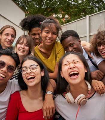 Selfie of a group of students looking at the camera laughing. Happy to be back at school and be together with their classmates.